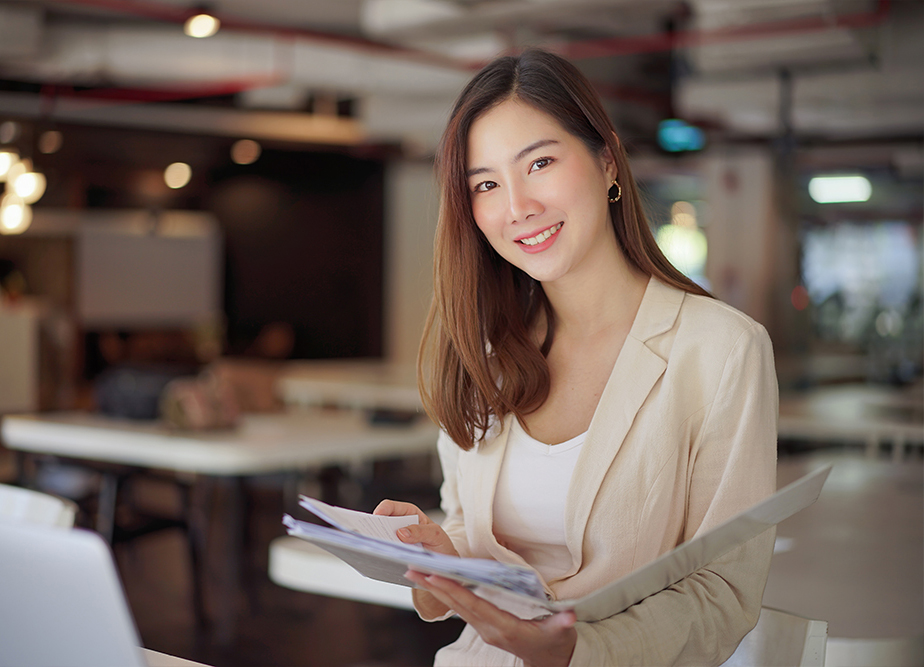 A professional female Altselino VA smiling while organizing business documents.