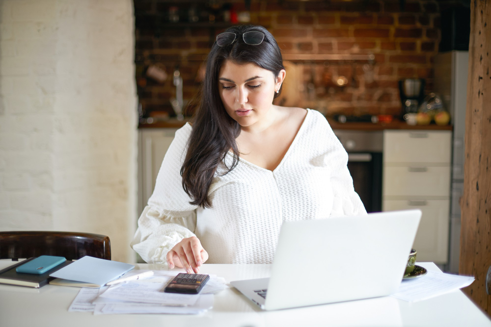 A professional virtual assistant from Altselino working on a laptop with financial documents.