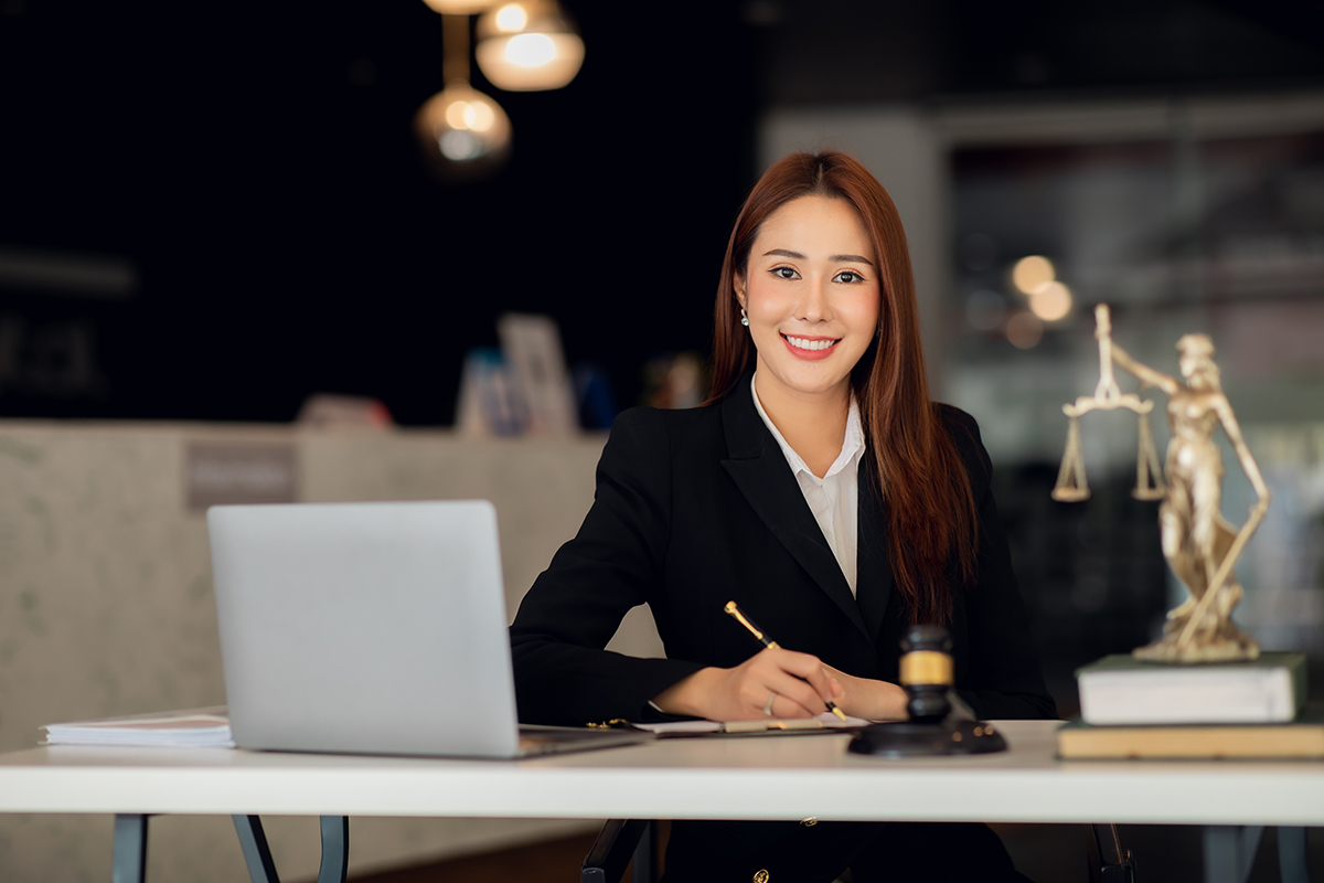 A professional female legal assistant from Altselino working on a laptop in a modern office.