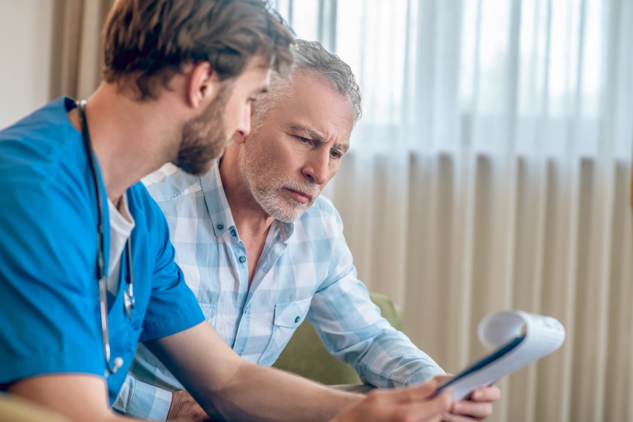 Altselino team members discussing patient care documents in a collaborative medical setting.