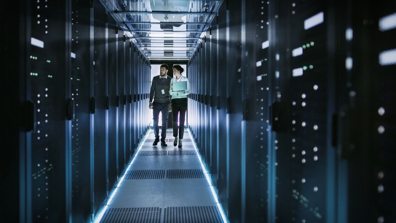IT professionals managing servers in a modern cloud data center.